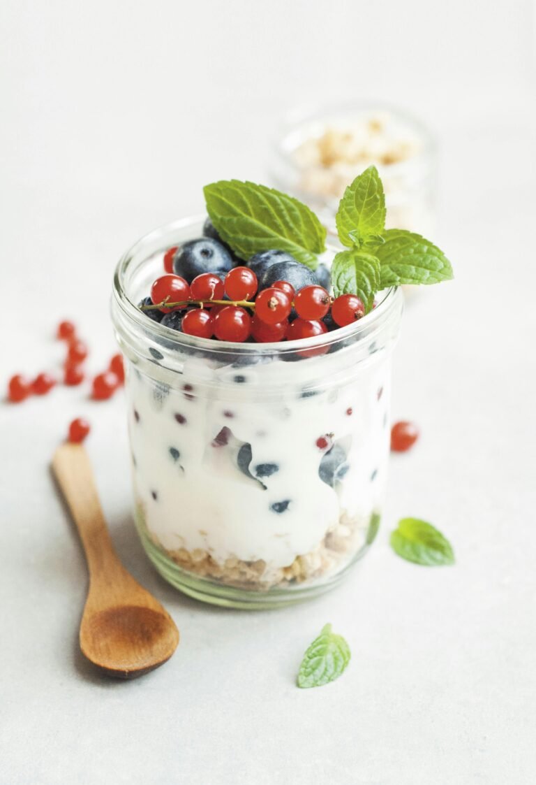 Glass with curd, blue berry, mint and spoon on the side