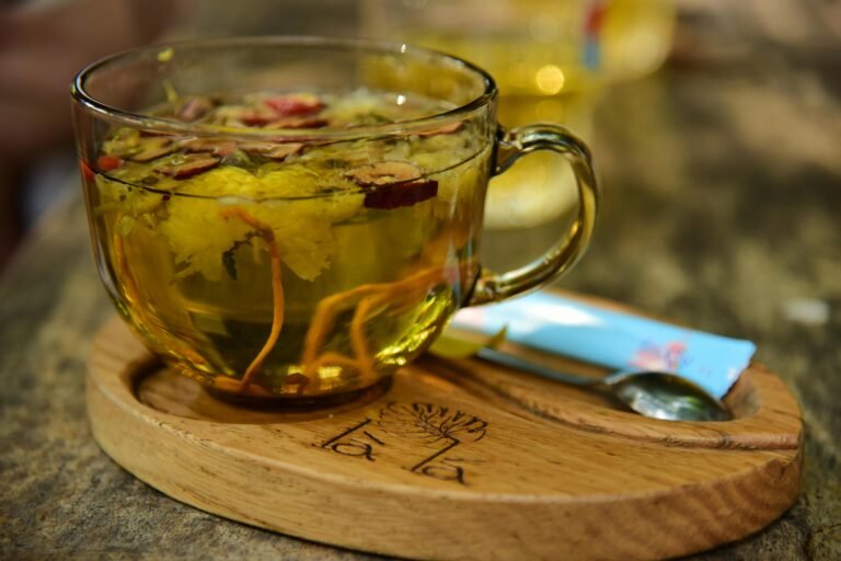 Green Tea in a transparent cup on a wooden tray